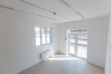 Office extension that uses bricks as a wall, construction, improvement. Interior of small room with window and bricks walls renovation, extension, overhaul and reconstruction.