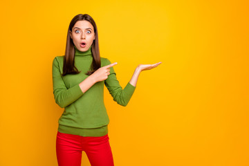 Portrait of amazed shocked girl hold hand indicate promotion impressed scream wow omg wear good looking outfit isolated over yellow color background