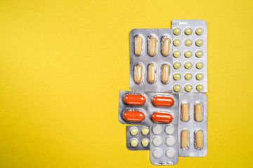 Bright pills on a yellow background. Medicines for the virus. Medicines.