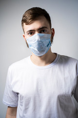 A bearded man in a medical mask looks at the camera. Self isolation