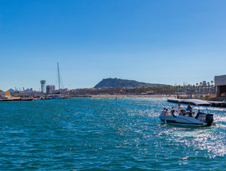 In the port of Barcelona with boats, motorcycles and bicycles.