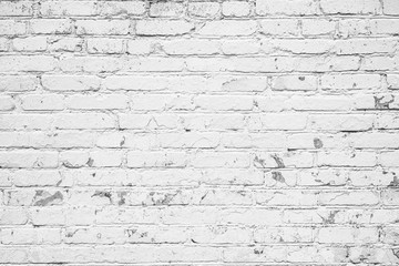 Old white brick wall with partially peeling paint.