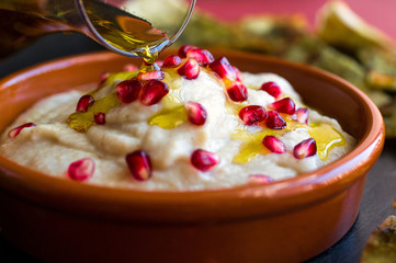 Close up of eggplant yogurt dip with pomegranate seeds and olive oil