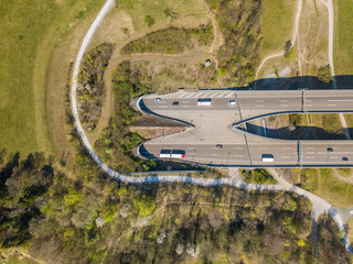 Aerial view of highway tunnel in spring landscape. Concept of traffic through mountain.