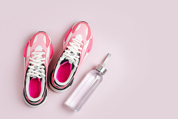 Fashion women's sneakers with water bottle  on a pink background. Female sport shoes.  Fitness concept. Top view, flat lay