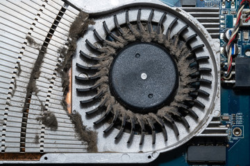 Dust on the computer pc processor cooler with mainboard and computer case fragment. Selective...