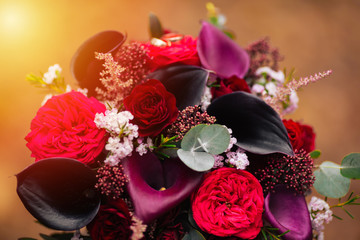 Wedding bouquet of red and pink roses and peonies