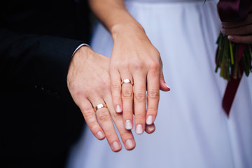 Wedding couple holding hands, classic wedding rings