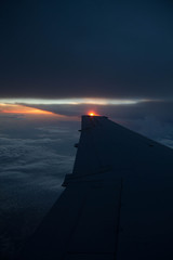 Fototapeta na wymiar cloudy sunset sky over plane wing
