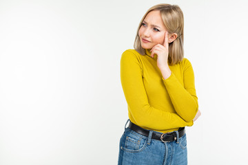 girl in a yellow blouse and jeans thought on a white studio background