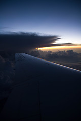 Fototapeta na wymiar cloudy sunset sky over plane wing with thunderhead