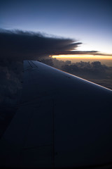 Fototapeta na wymiar cloudy sunset sky over plane wing with thunderhead