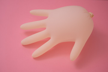 Inflated latex rubber glove isolated against pink background