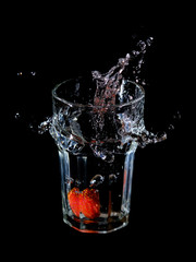 Wasserspritzer durch eine ins Glas fallende Erdbeere