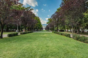Como, ITALY - August 4, 2019: Local people and tourists on Viale Guglielmo Marconi near Como lake. Tempio Voltiano museum on the background. Warm sunny summer day in very popular holiday destination