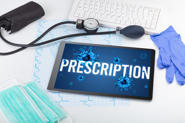 Tablet pc and doctor tools on white surface with PRESCRIPTION inscription, pandemic concept
