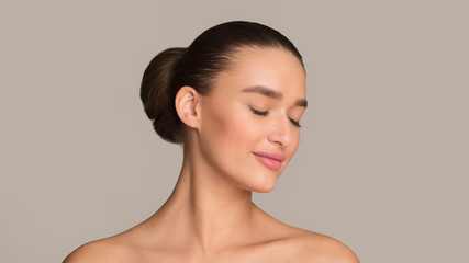 Young woman with hair bun and closed eyes