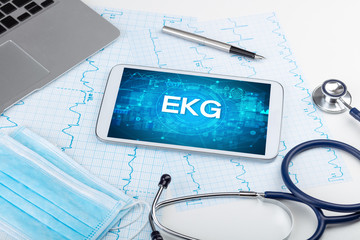 Close-up view of a tablet pc with EKG abbreviation, medical concept