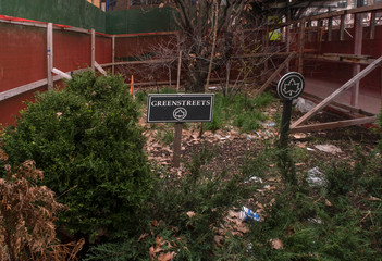 small plot of land, full of debris, surrounded by plastic fencing, in the process of being transformed into a small park in the Greenstreets program, on a street  in Lower Manhattan, NYC