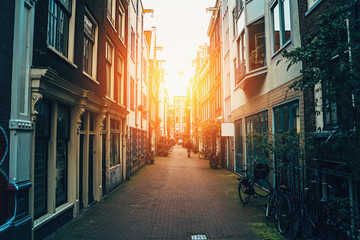 Fototapeta na wymiar Street of Amsterdam, old narrow street in downtown at sunset, toned