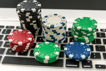 Different of cost casino chips stacking on a laptop. Gabmling