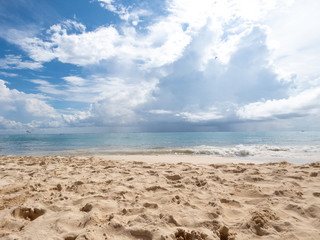 Fototapeta na wymiar sand beach and blue cloudy sky