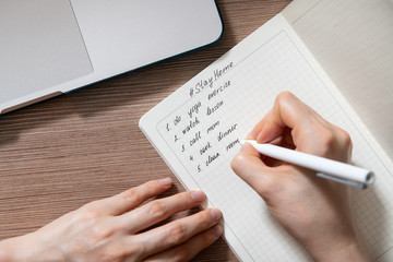 Woman writing todo list while stay home caused by coronavirus isolation