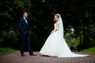 Bride and groom in a park kissing.couple newlyweds bride and groom at a wedding in nature green forest are kissing photo portrait.Wedding Couple