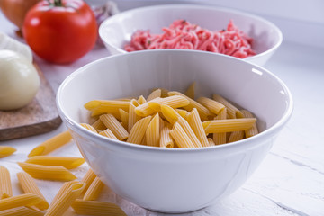 Macaroni, minced meat and other vegetables to prepare pasta bolognese. Homemade and traditional Italian cuisine. Close up view.