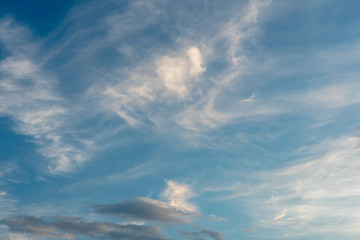 Beautiful fluffy clouds in the evening sky. The sunlight gives a side light on the clouds. Clouds before rain.