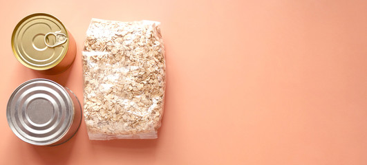 Dry goods, stockpiling, food supplies for staying home concept. Preserves, oatmeal on orange background, copyspace, banner