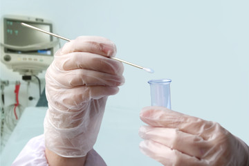 doctor holds in his hand a laboratory test tube with liquid, does an analysis on COVID-19 against the background of a ventilator, the creation of a vaccine for the SARS-CoV-2 virus, coronavirus, flu
