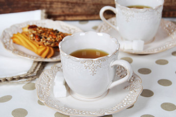 two retro cups with tea, sugar cubes and biscuits for breakfast
