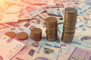 Close up coin stacked growing as financial  chart lying on ukraine money as background. For business growth