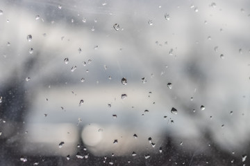 Raindrops on glass, gray sky, city outside the window