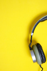 Wired headphones in khaki on a yellow background.