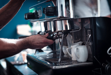 Close up of barista hands preparing cappuccino in cafe shop.