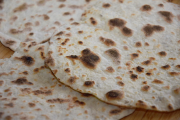 baked cake with spices in the shape of a circle on a hot pan for homemade baking flat bread