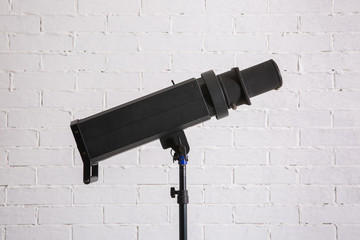 Large professional photo studio lamps on a white brick wall.