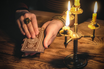 Fortune teller is reading a future by tarot cards close up.