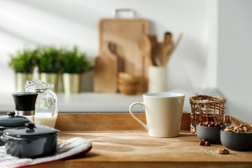 Wooden table in a sunny kitchen in the morning light during breakfast