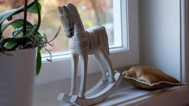 Kleines Schaukelpferd aus Holz zur Dekoration am Fenster