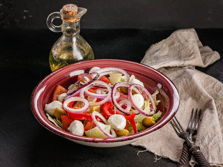 Vegetable italian salad with sweet pepper, red onion, tomatoes, mozzarella cheese and olive oil. Healthy and delicious Mediterranean cuisine