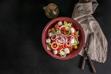 Top view vegetable italian salad with sweet pepper, red onion, tomatoes, mozzarella cheese and olive oil. Healthy and delicious Mediterranean cuisine. Copy space