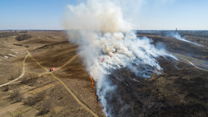 Large dry grass fire on hills near city.