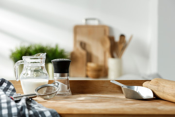 Wooden table in a sunny kitchen in the morning light during breakfast