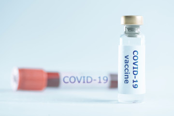 Vial with vaccine covid-19 and tube blood sample.