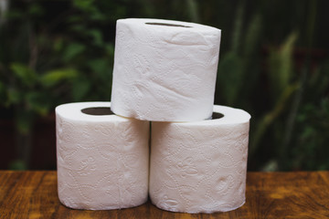 group of roll of white toilet paper on wood table