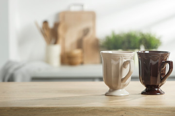 Wooden table in a sunny kitchen in the morning light during breakfast