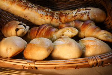 Cesta de pães, baguetes e croissants em cesta de palha.